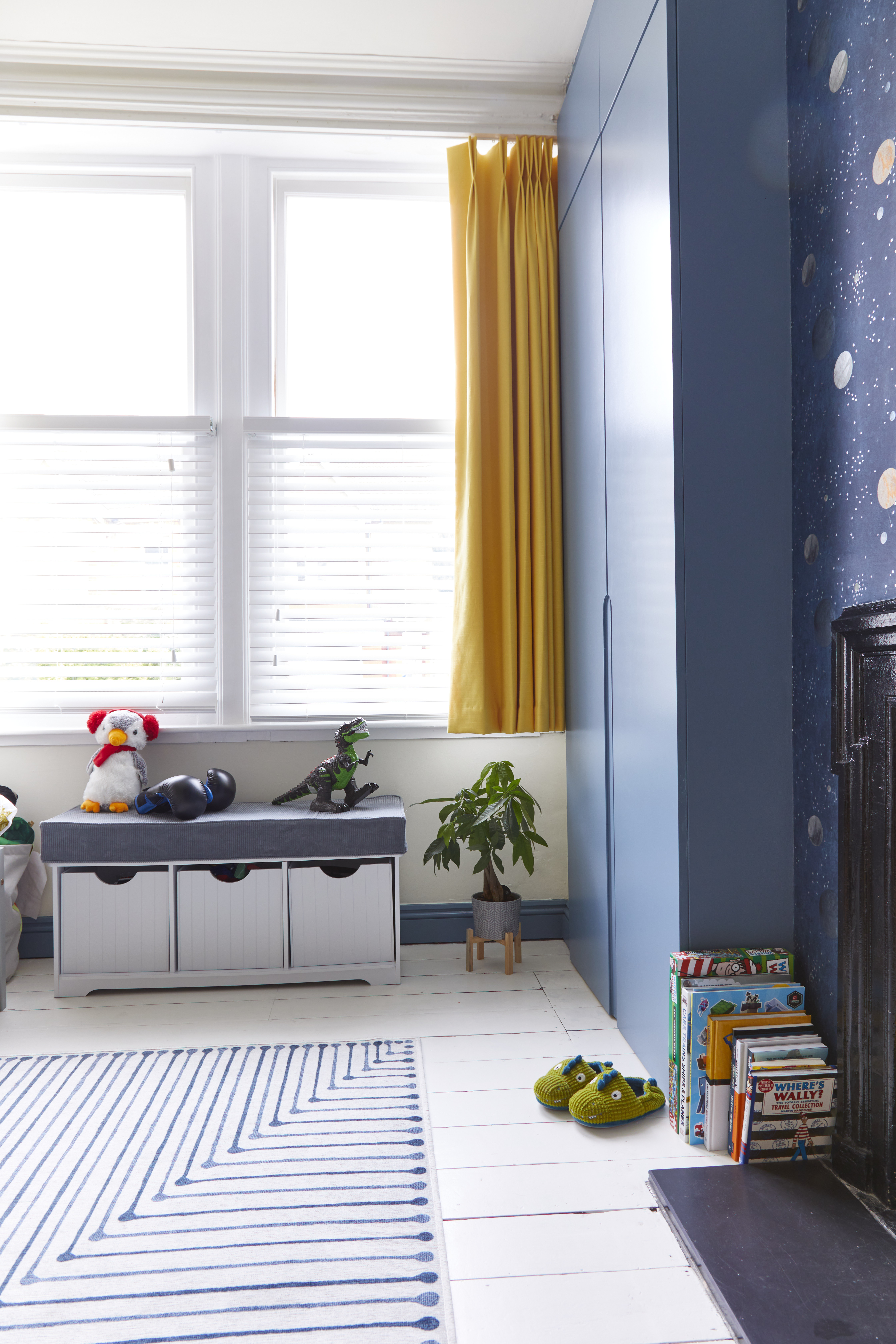 Boys bedroom with yellow curtain and blue wardrobe