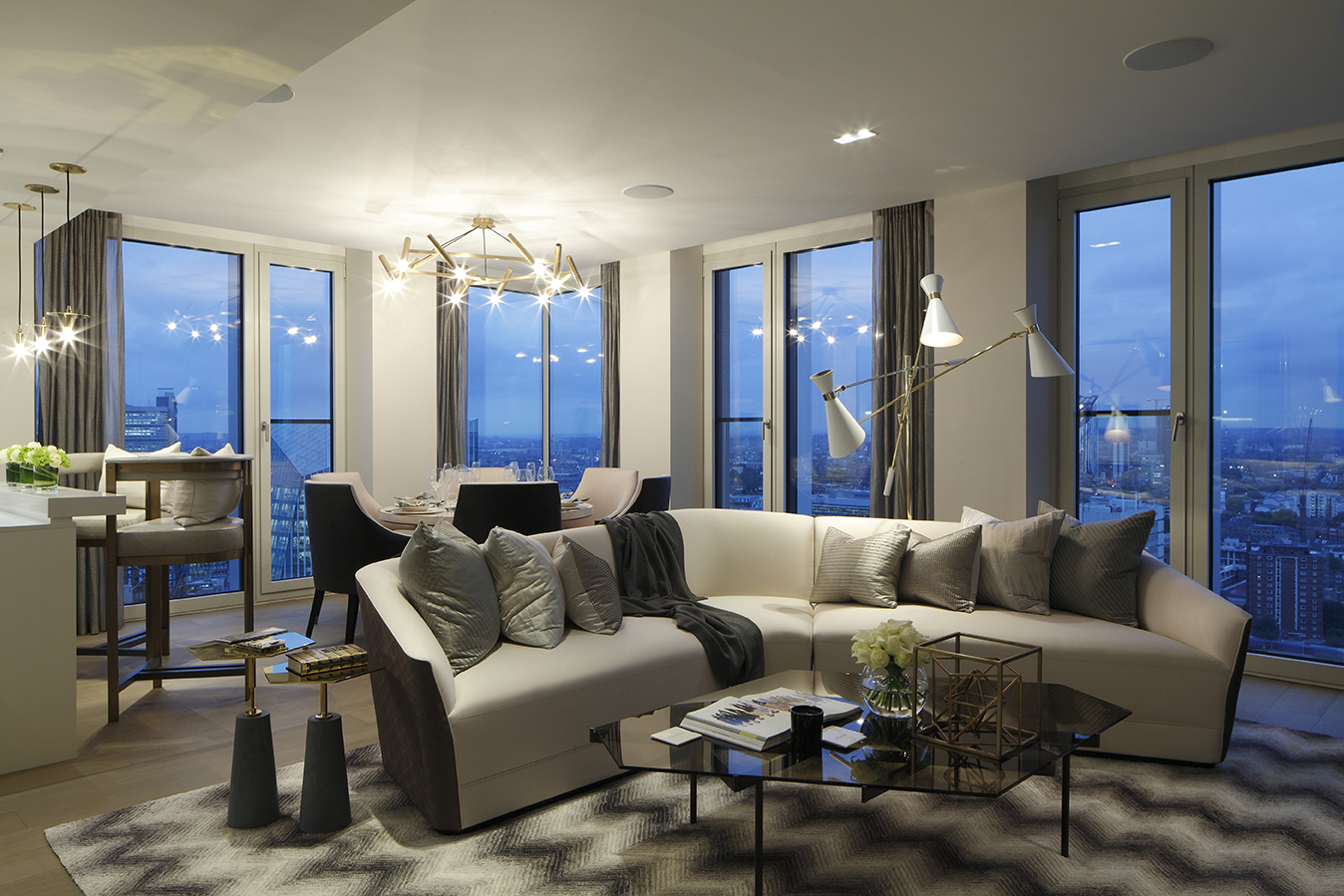 Angled cream sofa on a zigzag rug in a modern penthouse apartment with views over London