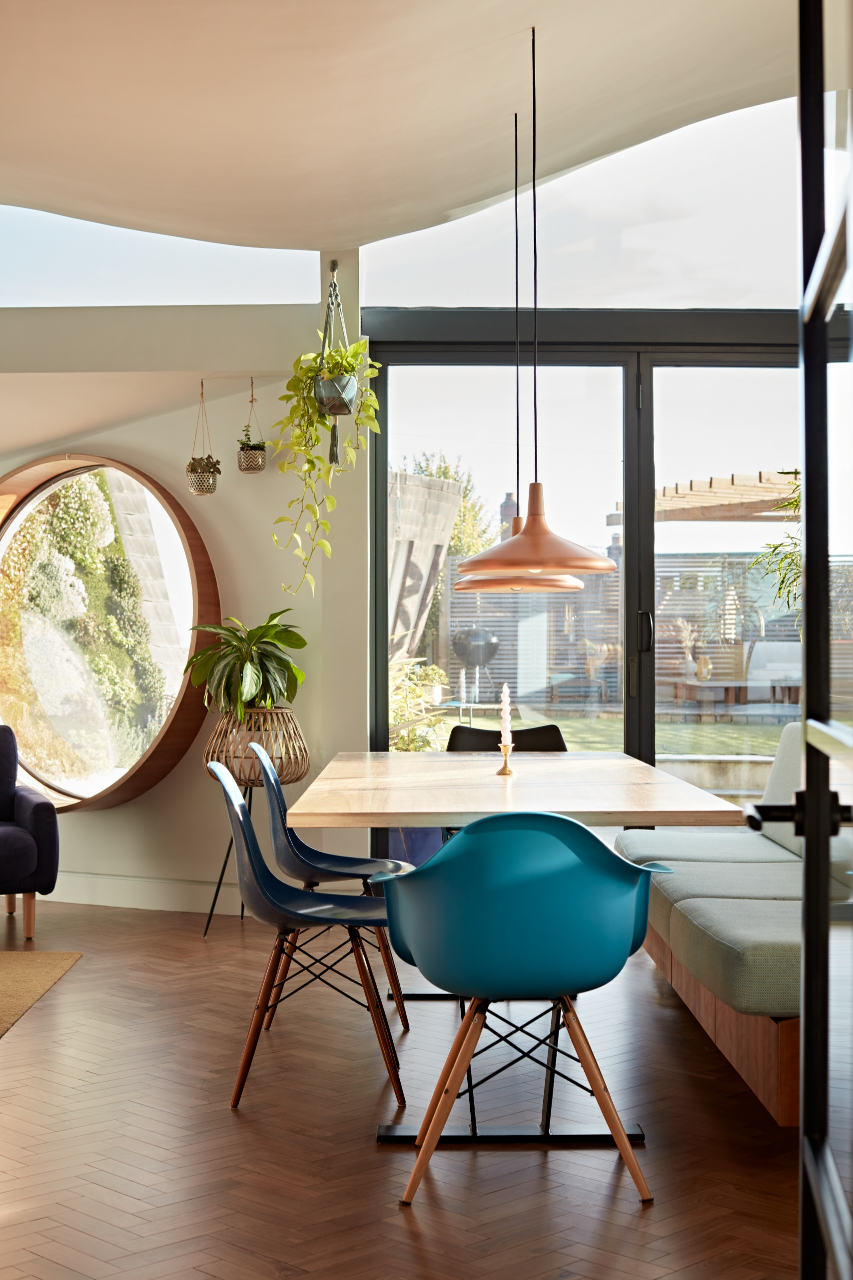 An open plan living area with double vaulted curved ceiling and feature circular window.