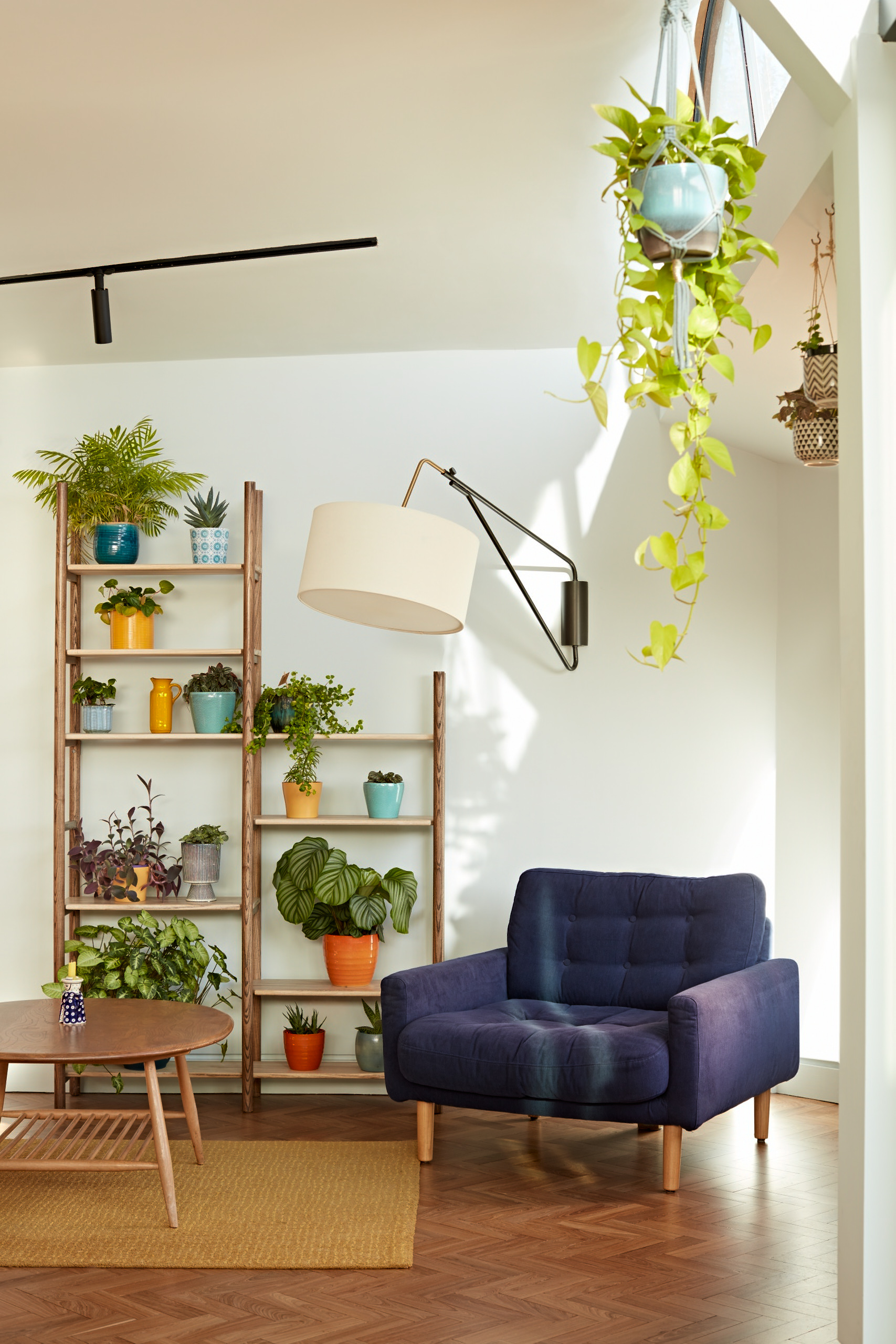 A light filled corner with bespoke shelving and reclaimed parquet flooring .