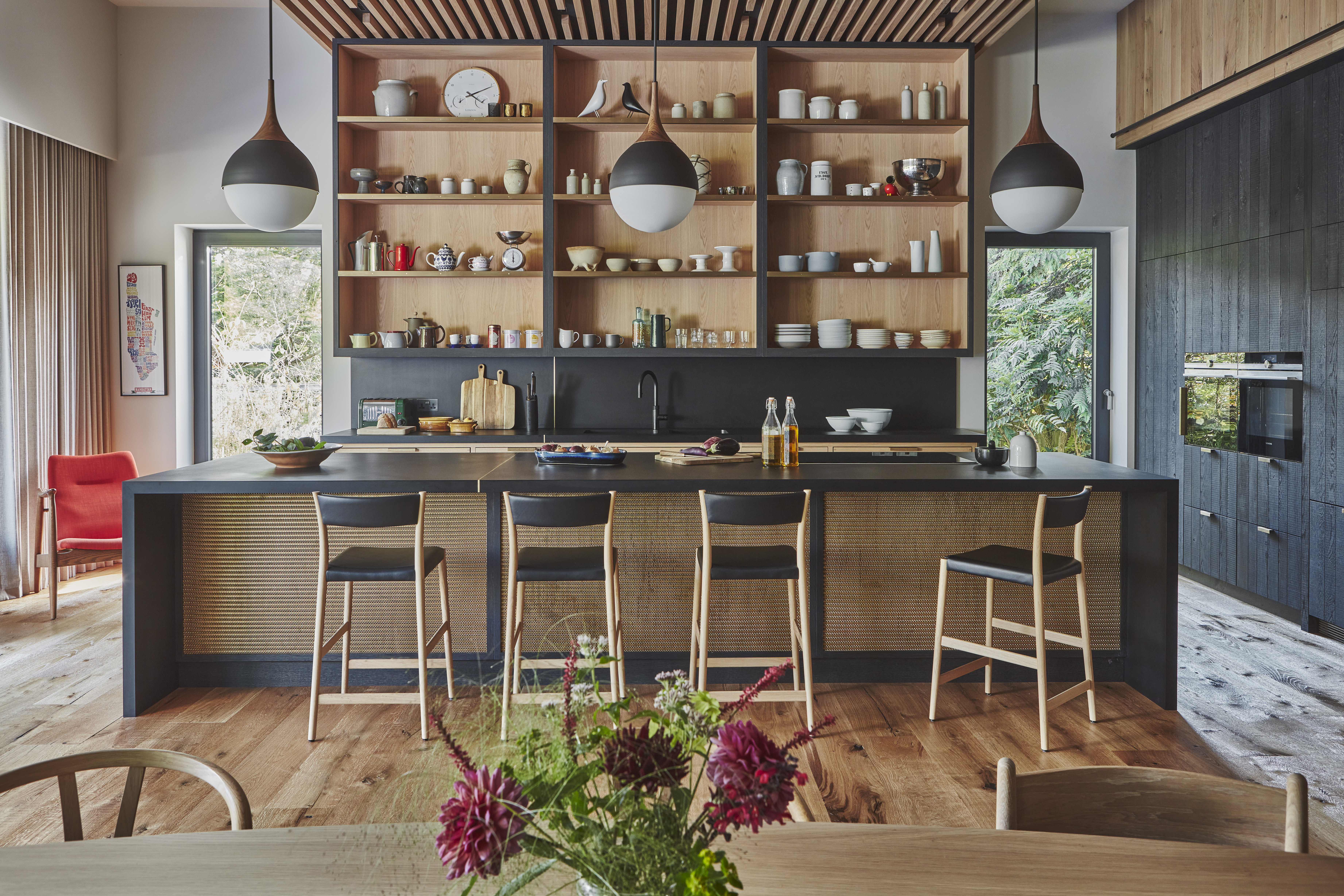 Kitchen and breakfast bar in navy and wood tones.