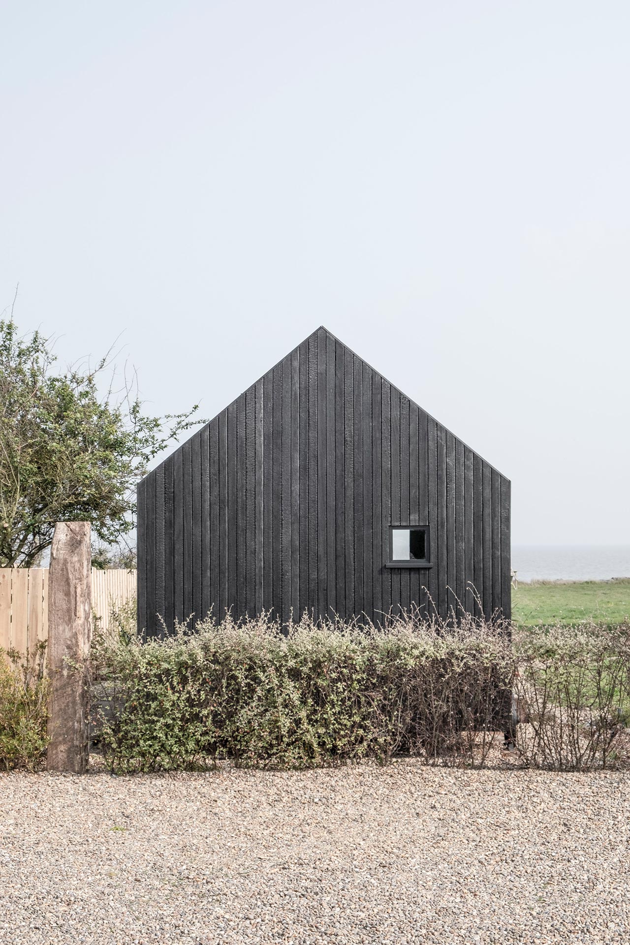 Black timber cabin next to the sea