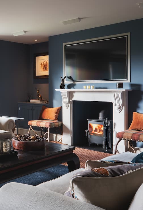 Deep blue snug room with open fire