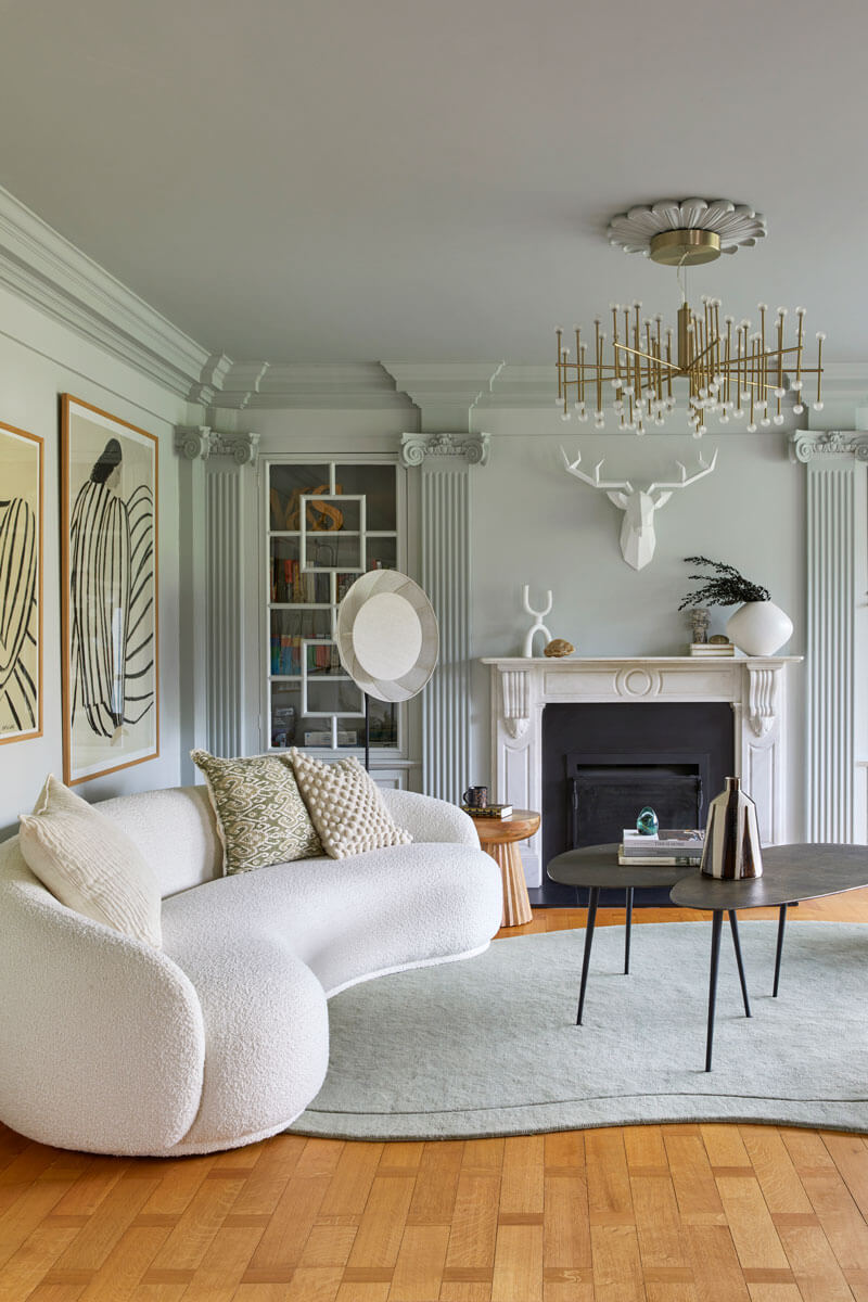 Living Room, with curved sofa nd green rug, fireplace and artwork