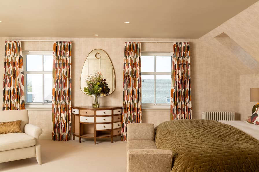 Patterned curtains, made bespoke to order. Statement mirror is hung above a quirky dresser.