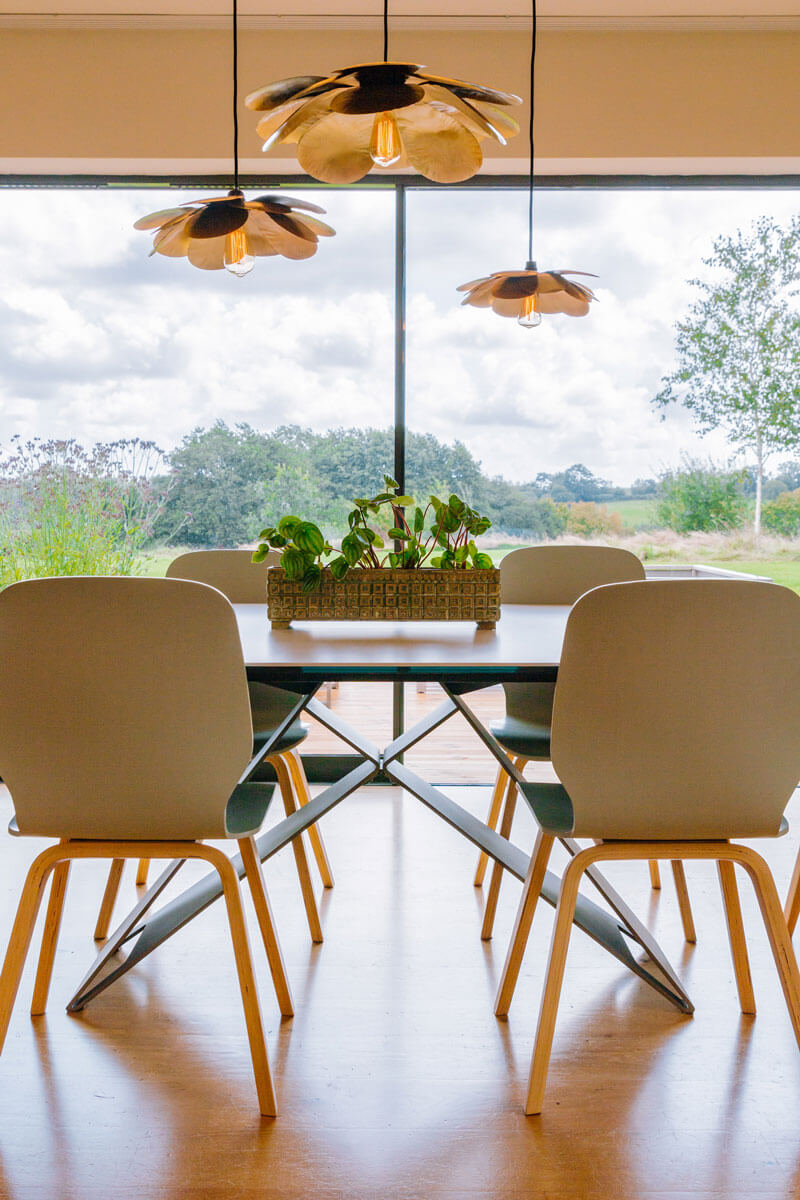 Dining Room with brass flower pendant and chairs