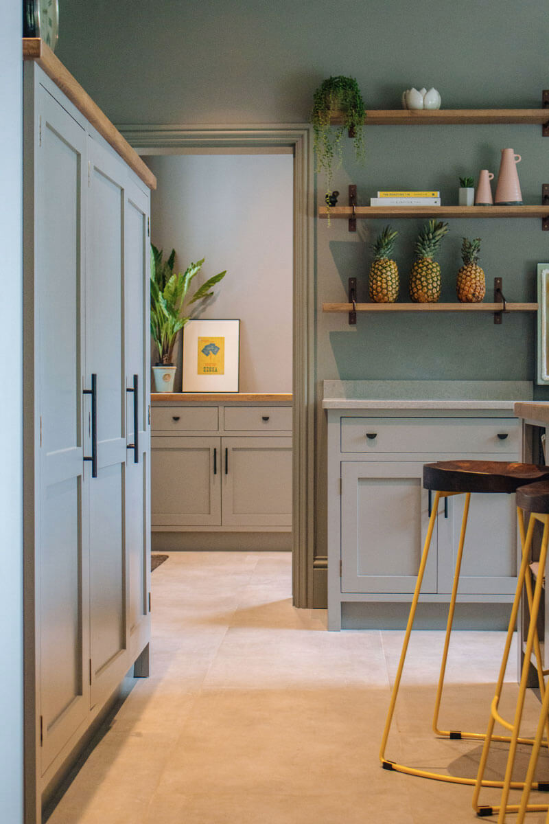 Bespoke kitchen through to utility with yellow stools