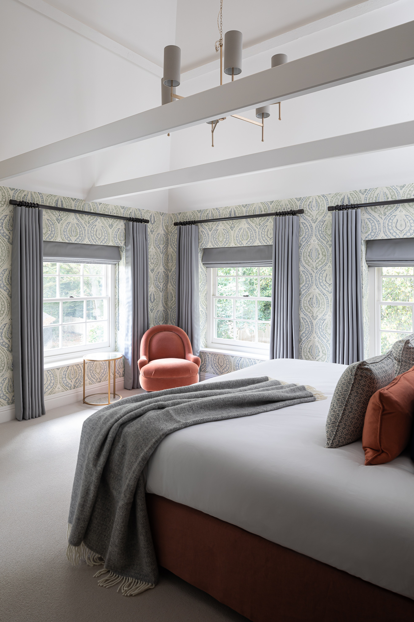 Vaulted bedroom with Lewis and Wood patterned wallpaper blue and green bedroom with pink coral  accent