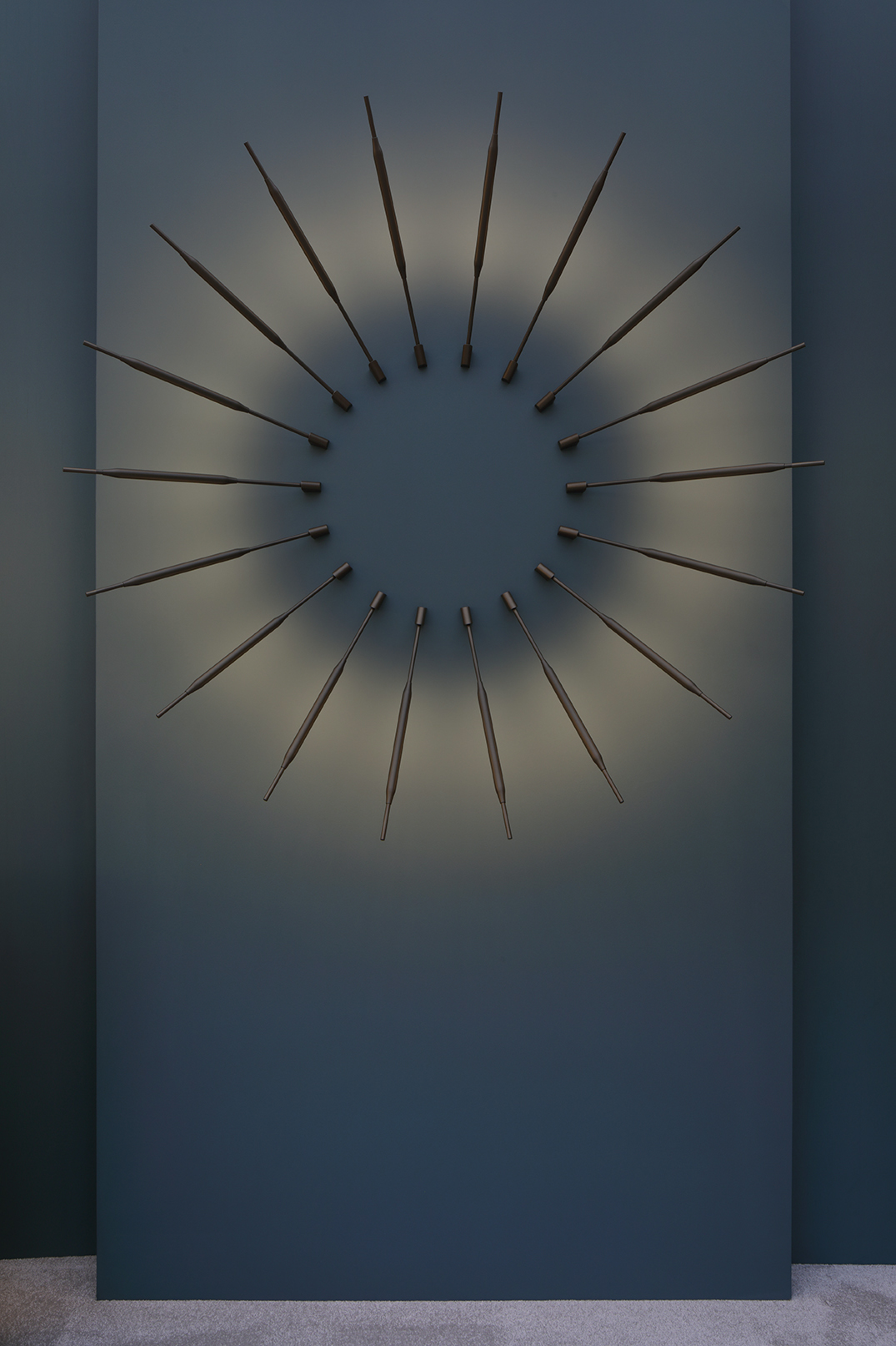 Contemporary metal sunburst style wall lighting on a dark blue backdrop