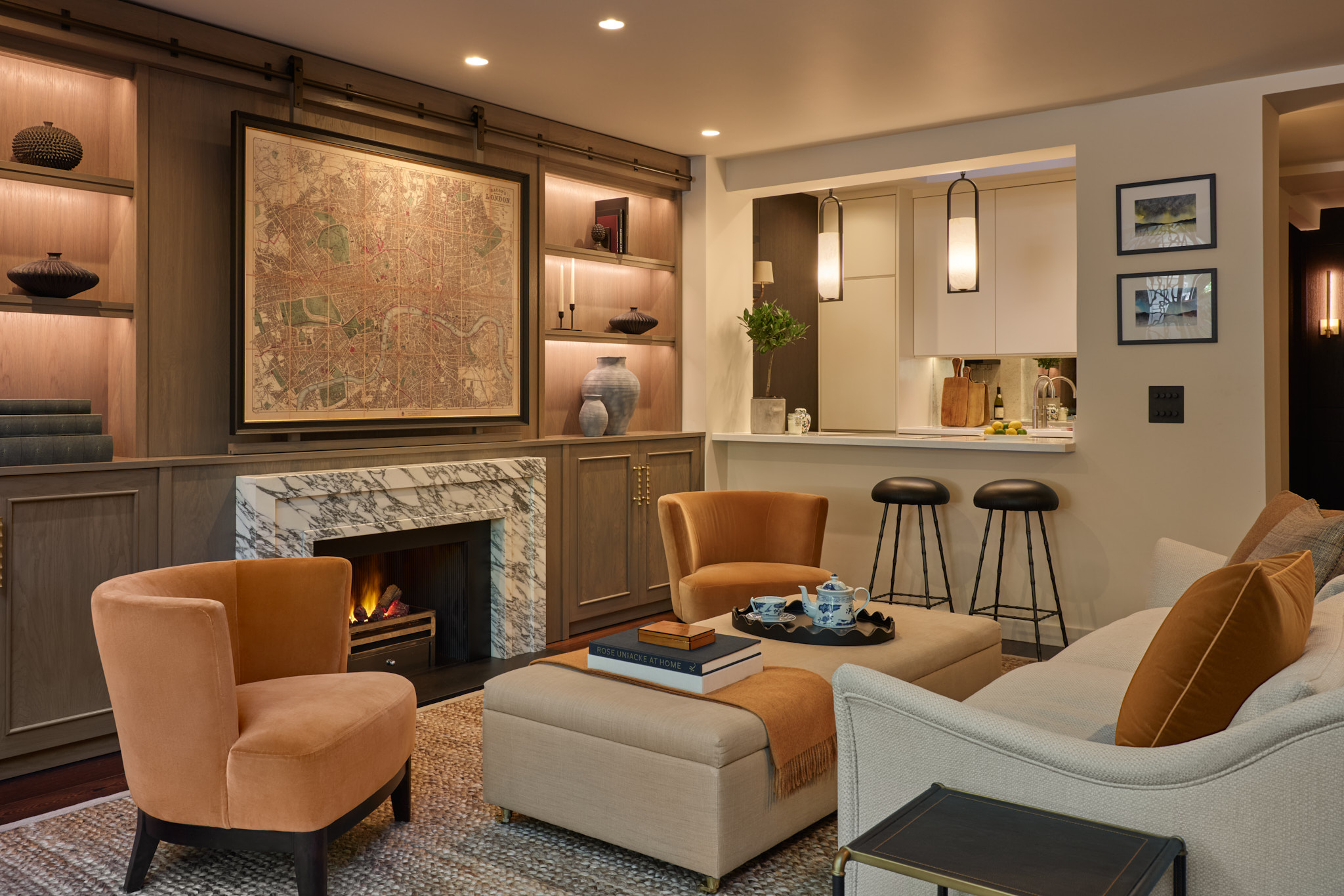 Marble fireplace in joinery wall with TV hidden behind artwork on sliding panel.  Living room with Ochre accents.