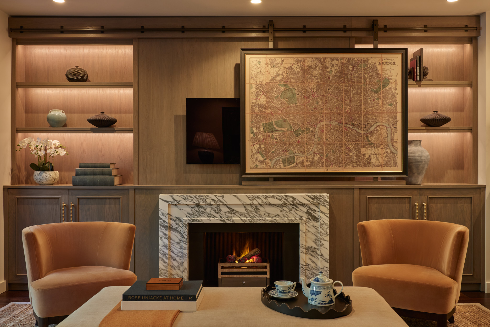 Marble fireplace within oak joinery and hidden TV behind artwork