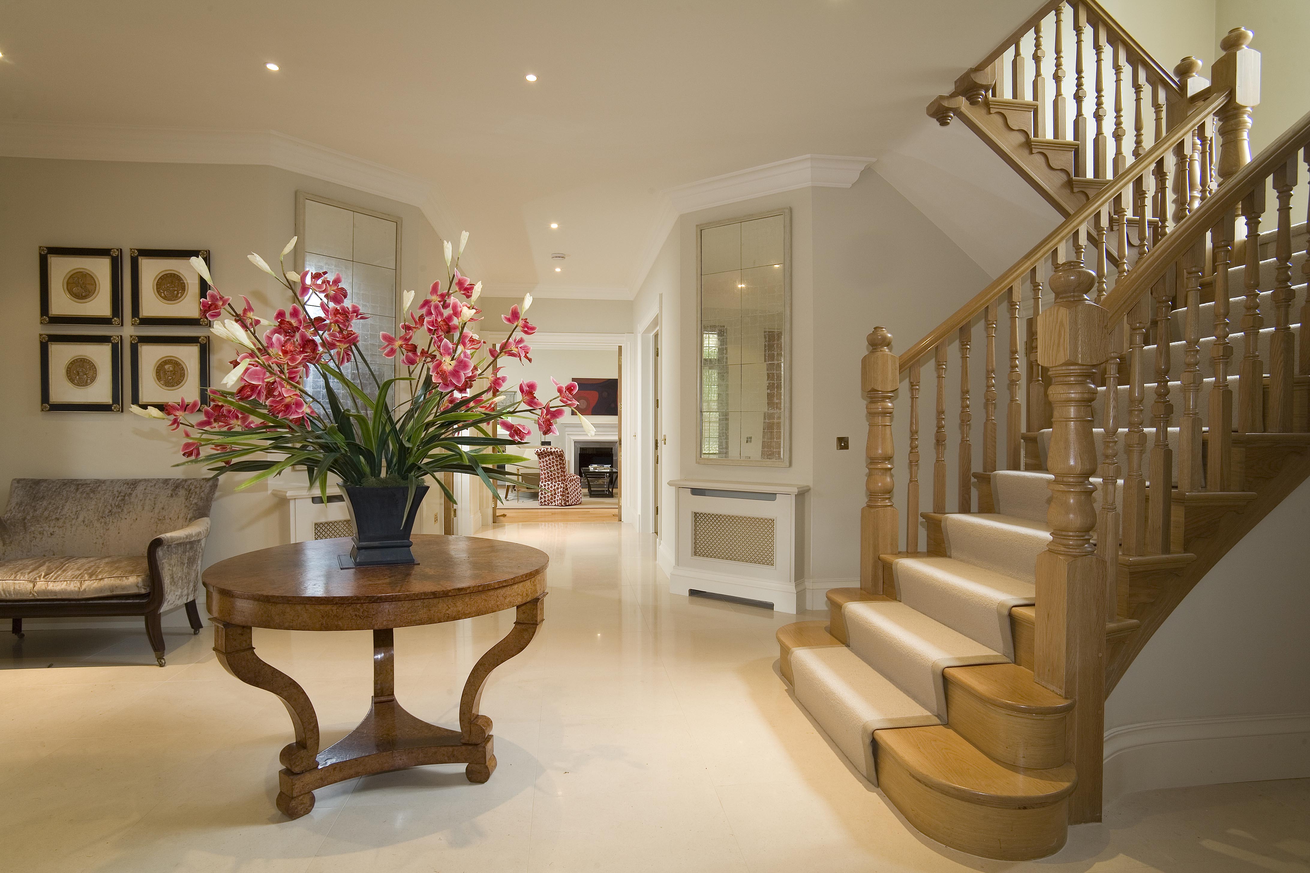 A lovely light entrance benefitting from a large polished limestone tiled floor and a pair of verre eglomise mirrors. 