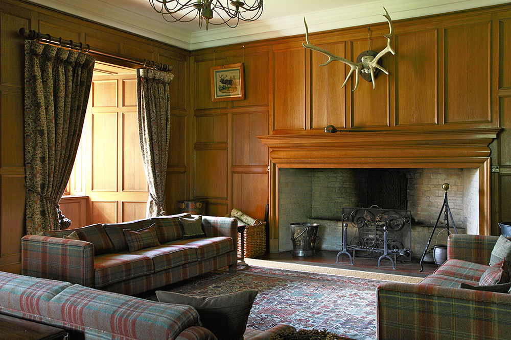 Tapestry curtains and plaid upholstery are the perfect combination with the antique fumed oak paneling of this sixteenth century room.