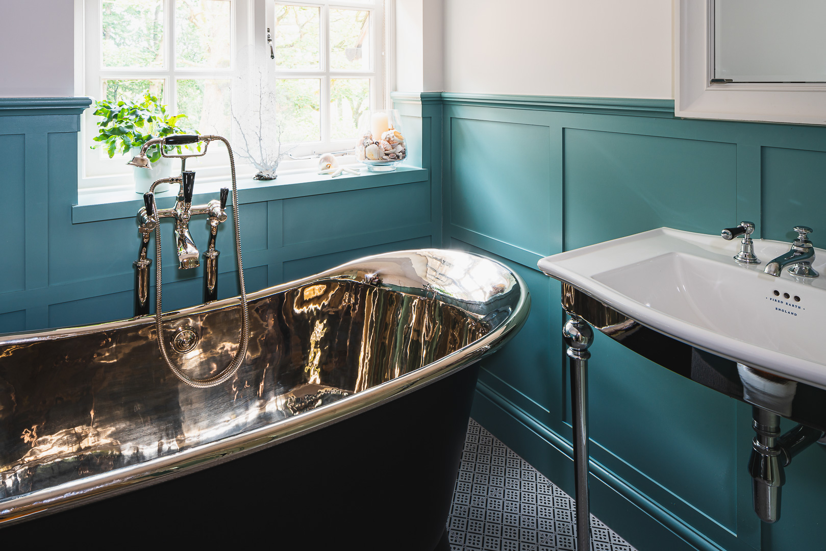 Free standing bath, blue shaker panel walls, chrome and black. 