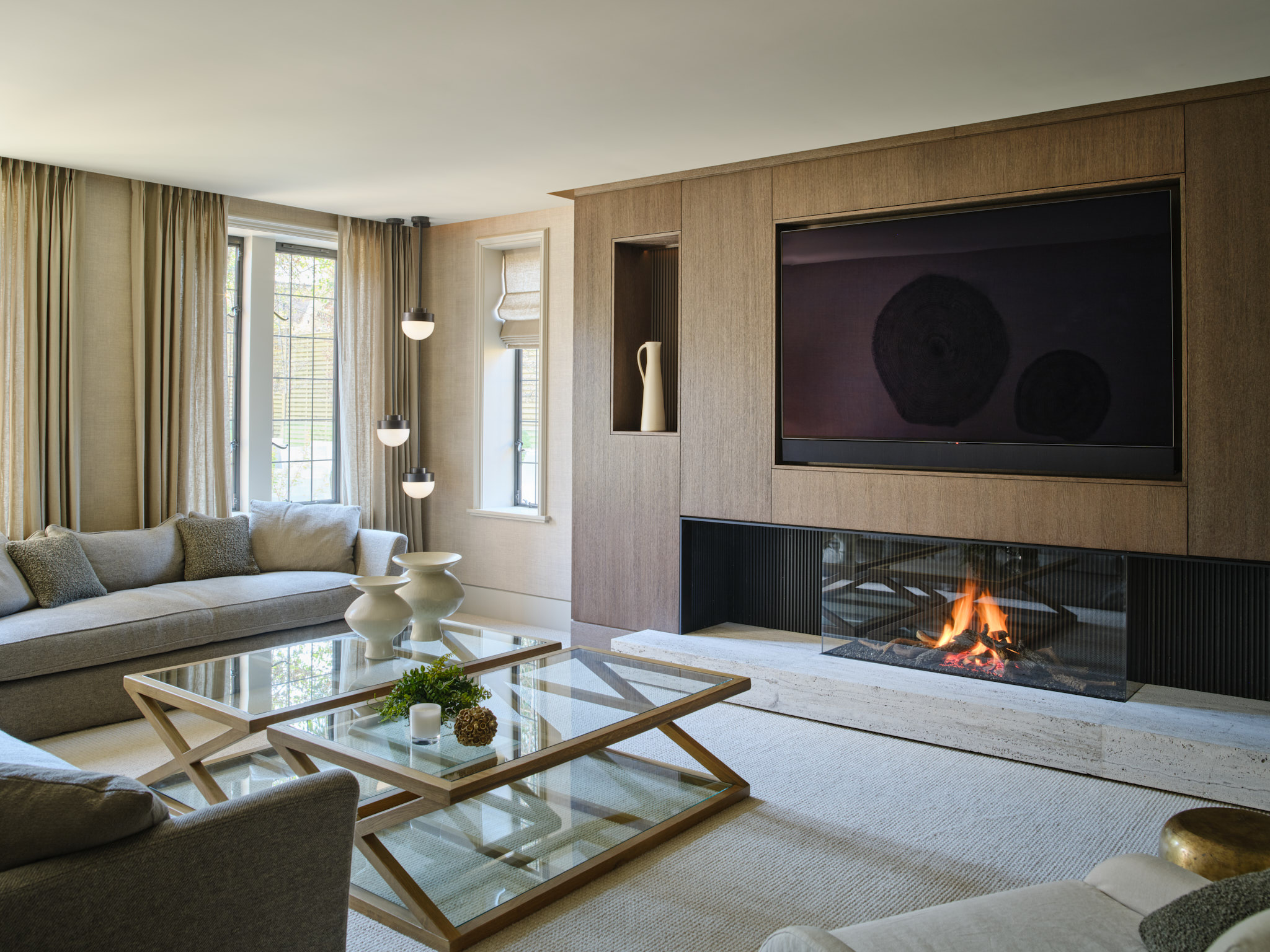 A wall of flat fronted cabinetry housing a large Tv in a snug