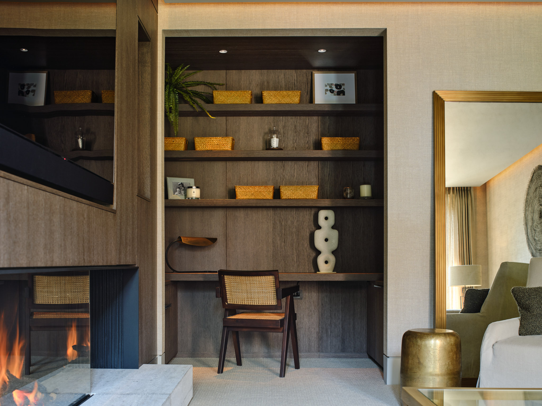 A study area with fitted desk and shelves above in dark stained oak