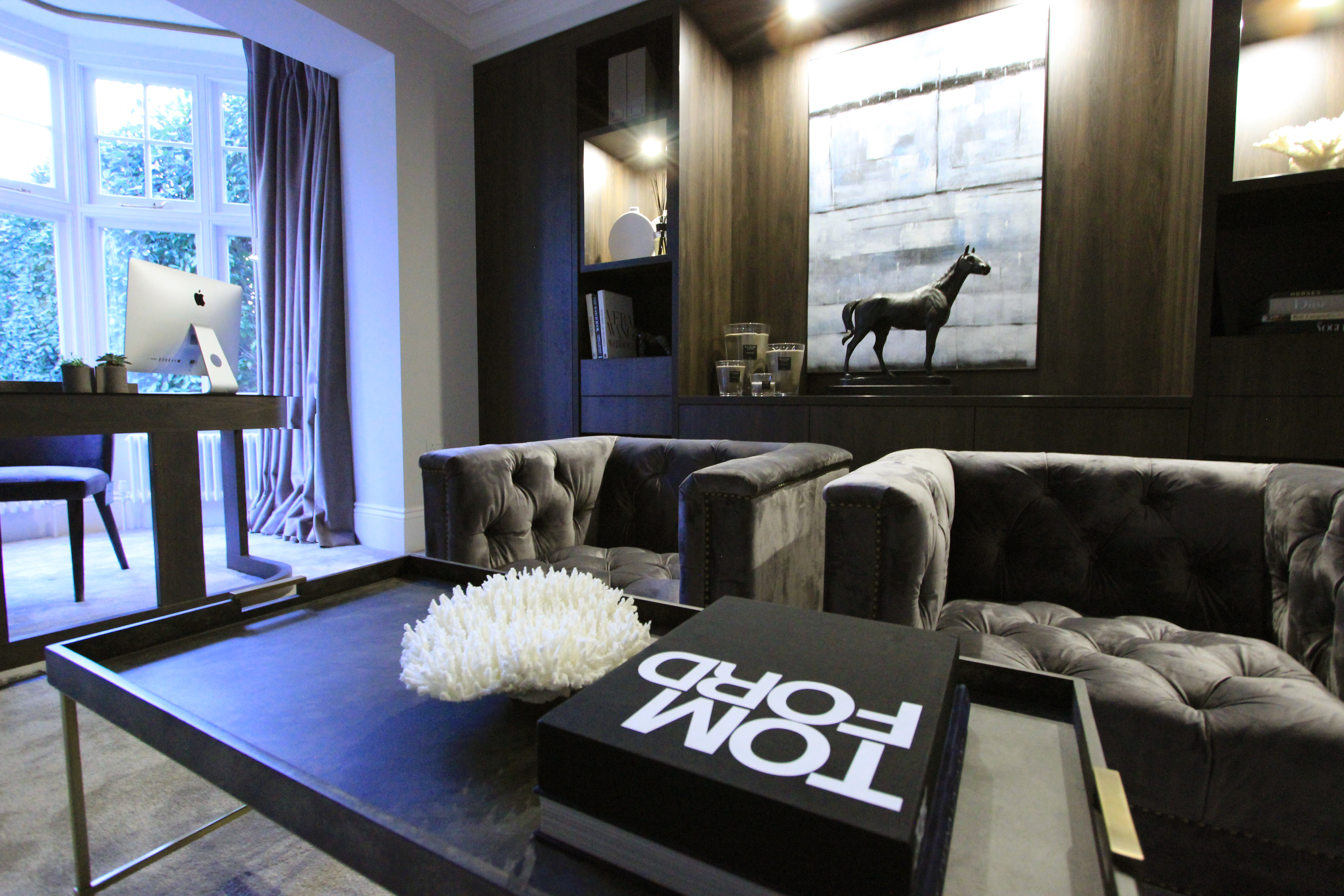 Dark home study with stained oak cabinetry deep buttoned velvet armchairs