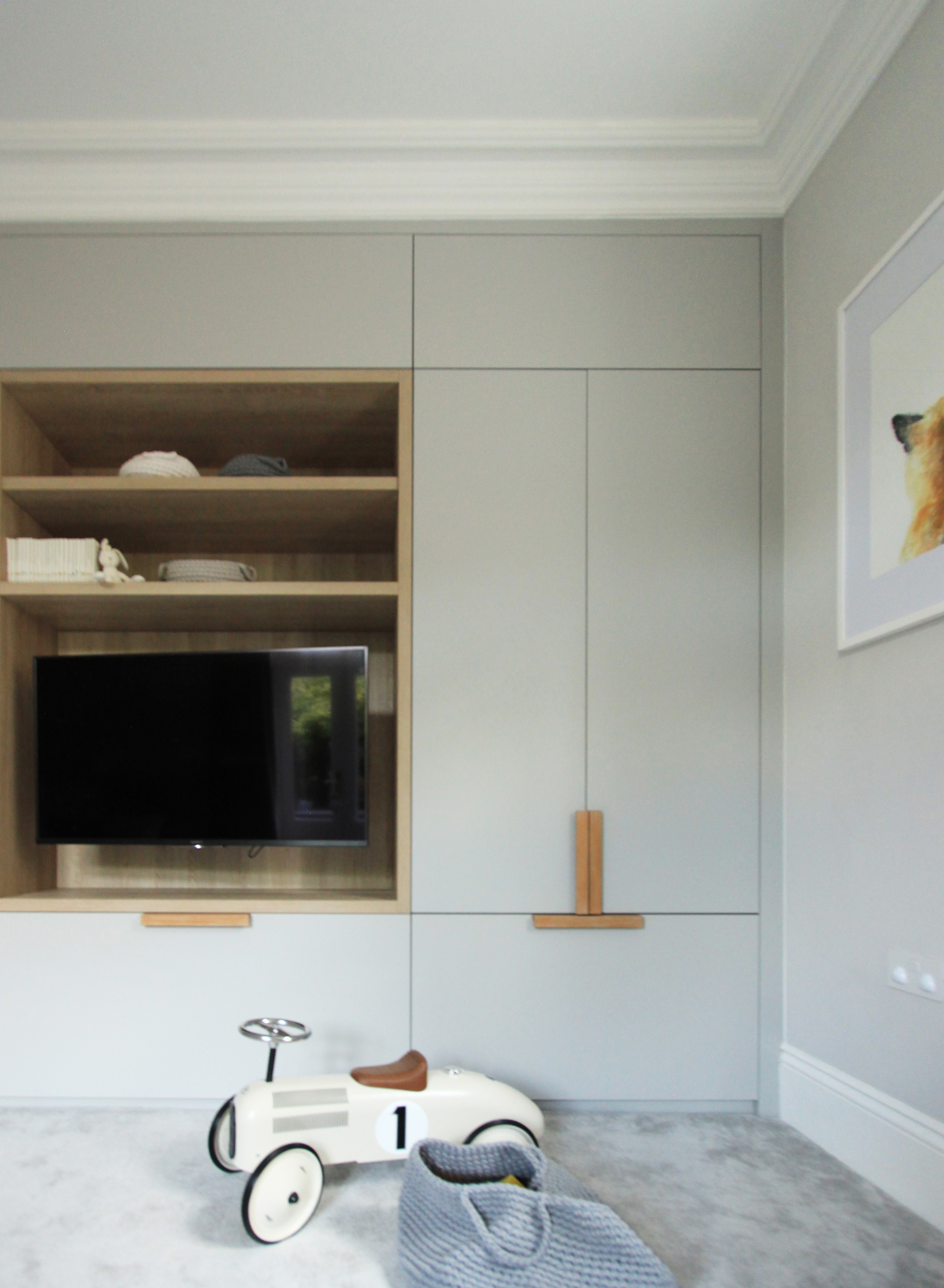 Neutral palette play room built in cabinetry with oak handles