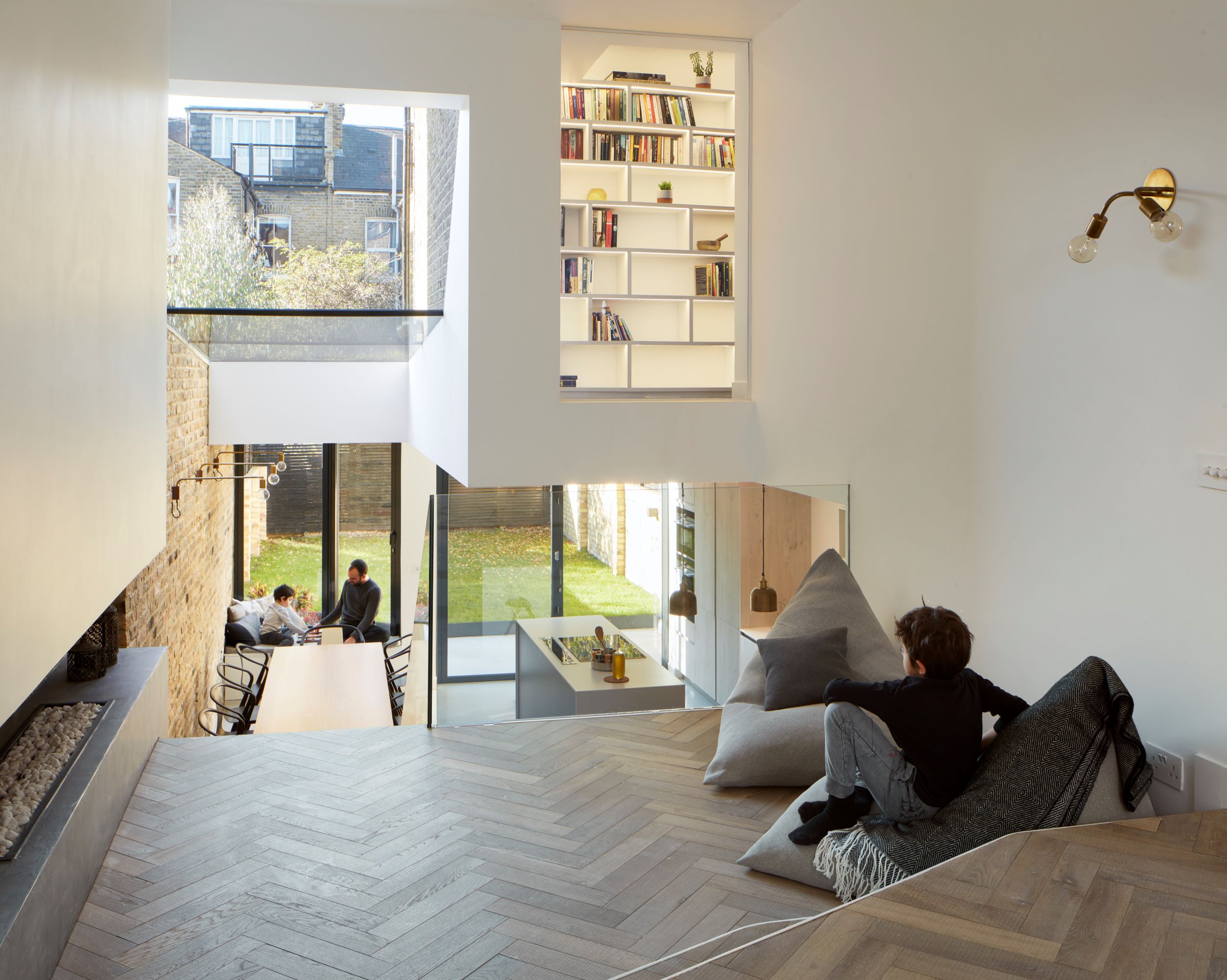 living room overlooking the open plan kitchen area with herringbone floor.