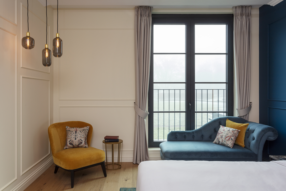 blue velvet chaise longue in hotel bedroom