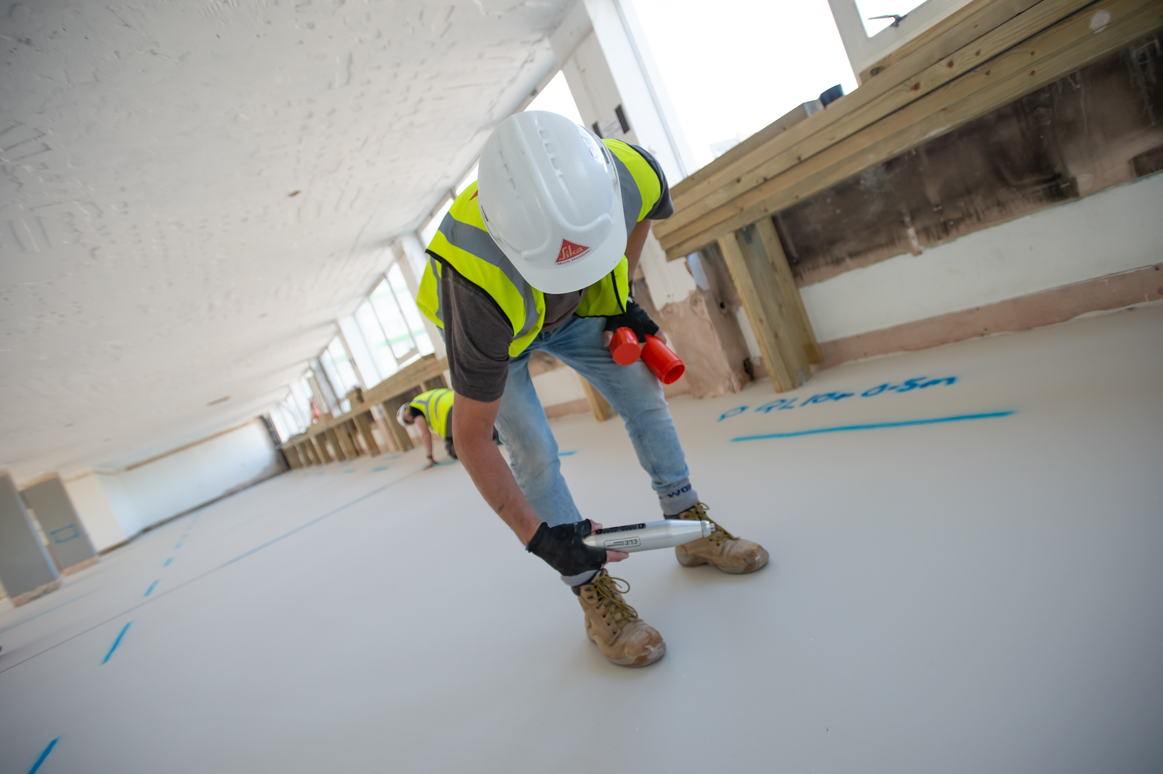 Using a Schimdt hammer to test the compressive strength of the floor. 