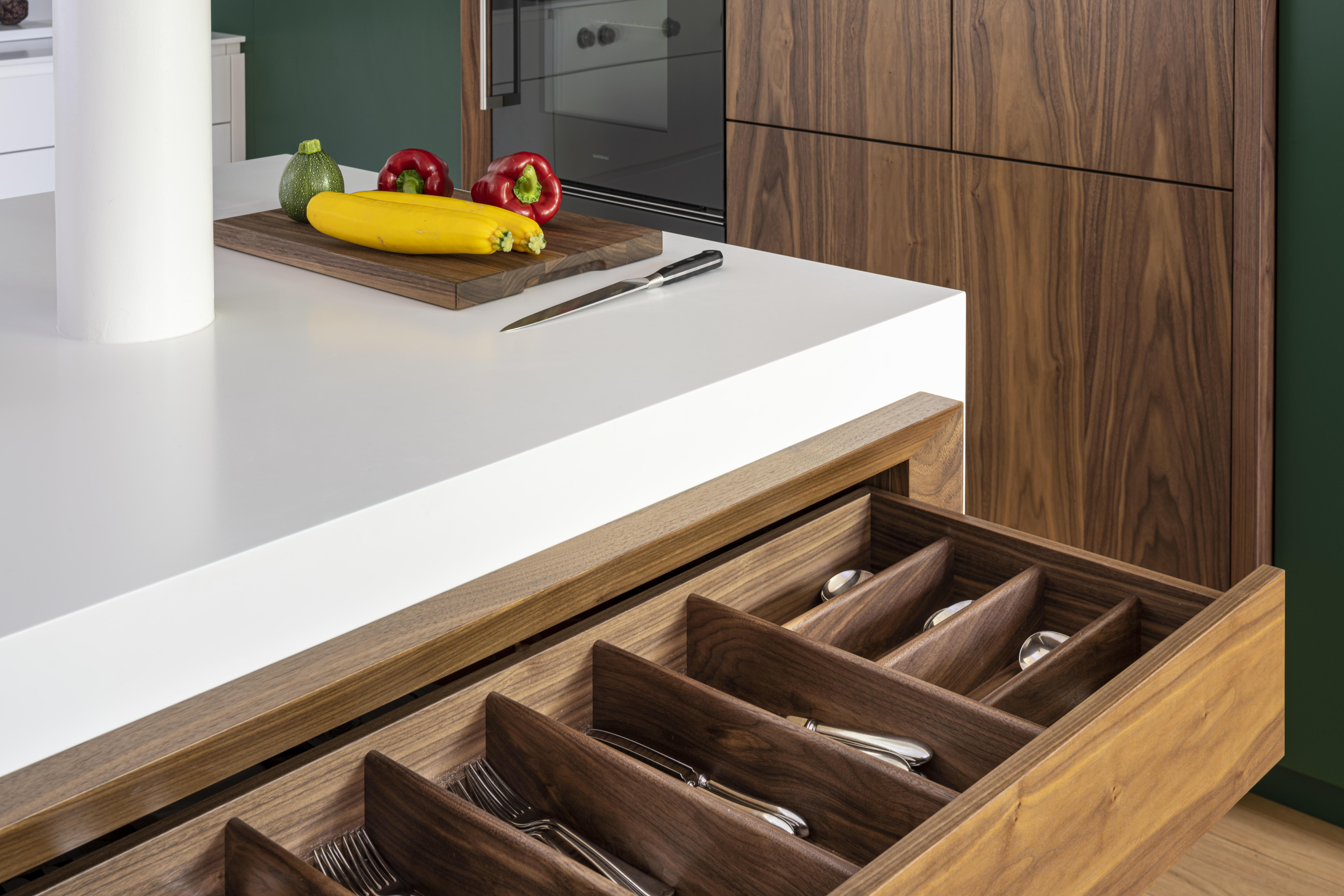 Walnut cutlery drawer within a Corian island