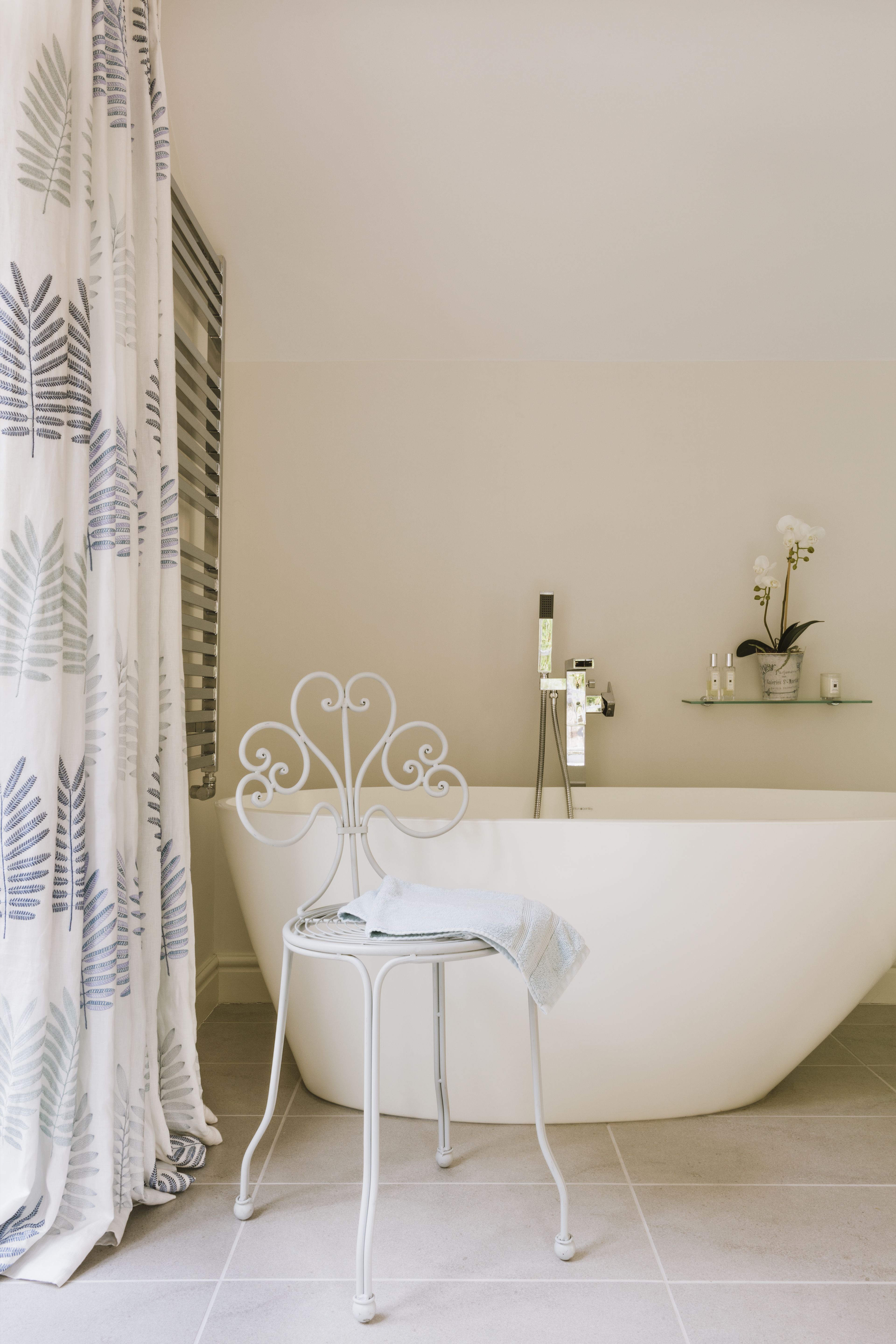 Bathroom with white linen curtains and freestanding bath