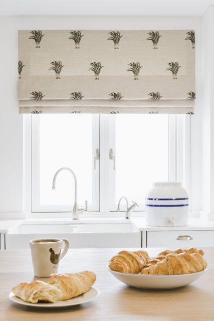 White kitchen in coastal home with Roman blind in Emily Bond fabric