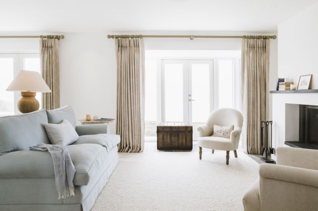 Coastal home sitting room with natural curtains and pale blue sofa