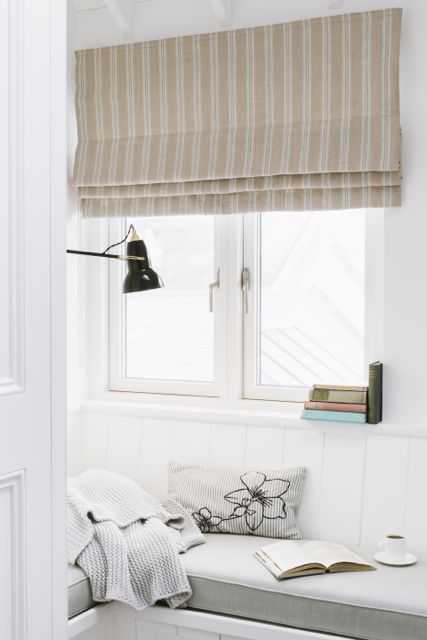 Coastal home window seat with deep cushion and linen Roman blind