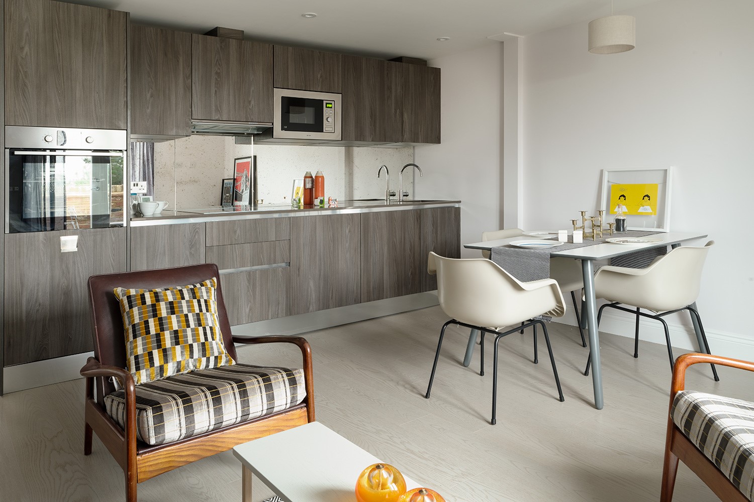 Modern British open plan living room, dining room & kitchen featuring Italian Kitchen units & antique mirror glass splash back.