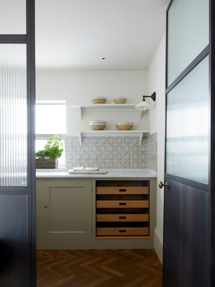 View into a kitchen larder with herringbone parquet .