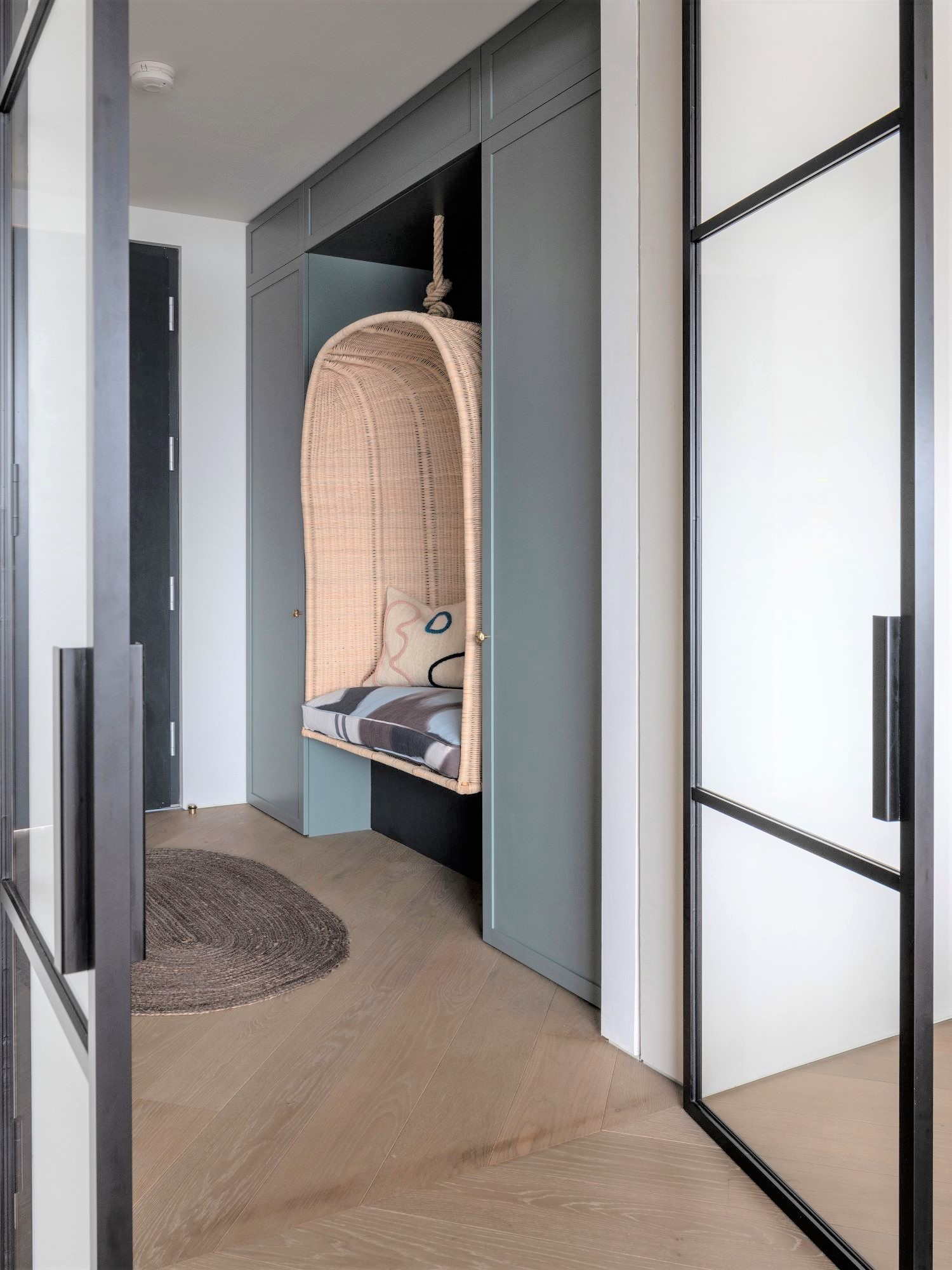 Hallway with hanging rattan chair.