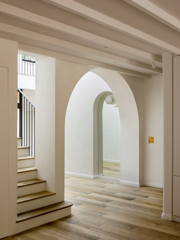 Entrance hall with arch, grey oak flooring and matching staircase.