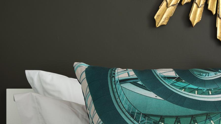 Cushion in shades of teal and turquoise printed with image of the spiral walkway at London's former City Hall