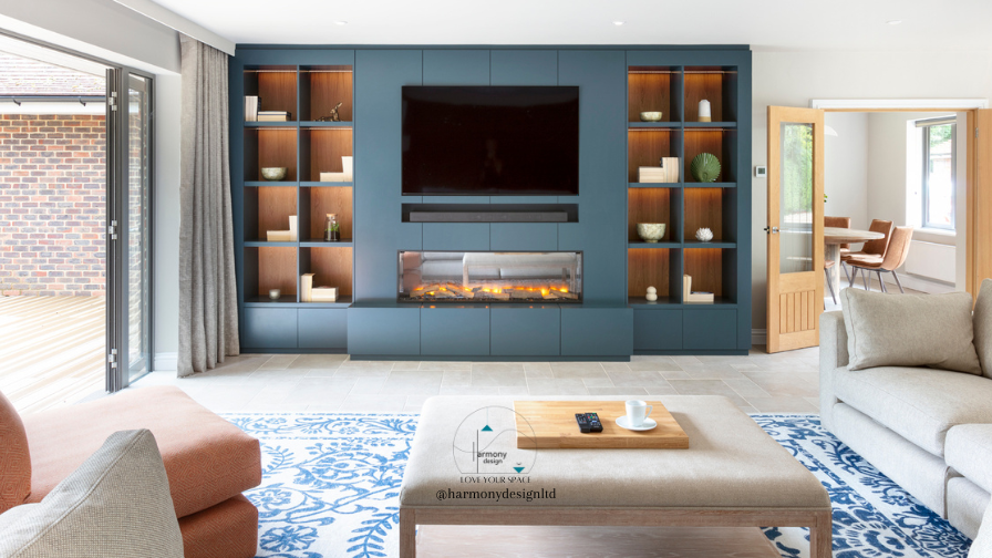 Lounge dark blue media unit with open walnut shelving, electric fire, soundbar and flush TV.