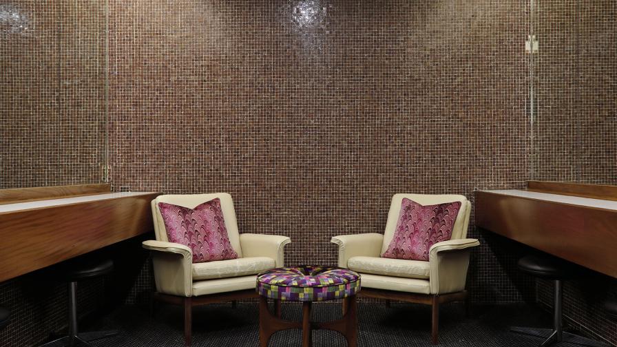 Susi Bellamy cushions and fabric covered footstool in the mosaic tiled ladies' powder room.