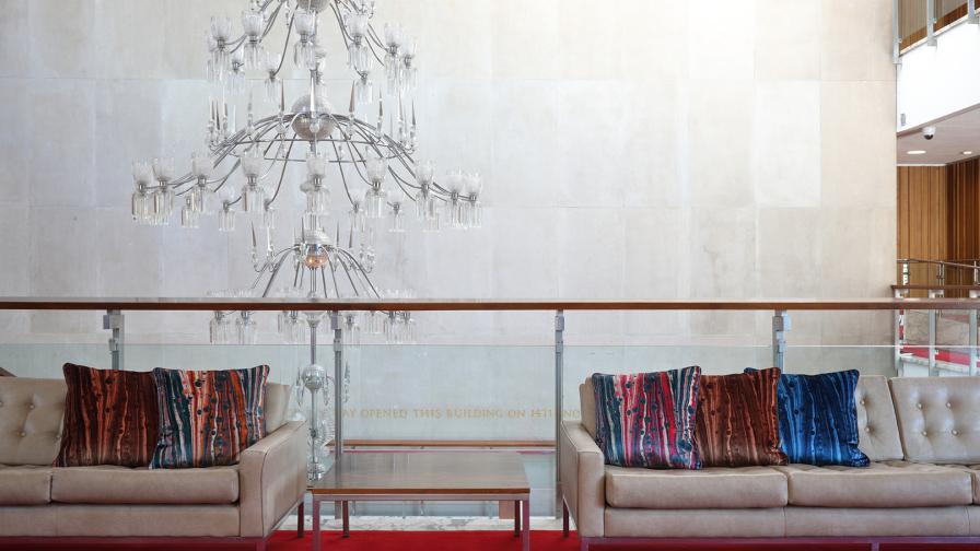 Grand stairwell at Newcastle Civic Centre with chandelier and red carpet. Susi Bellamy cushions on cream button backed sofas