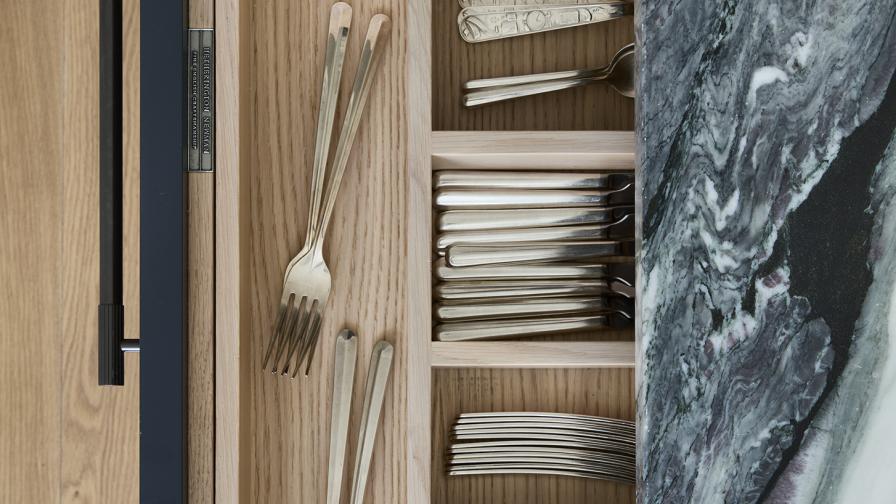 An aerial view into an oak lined cutlery & knife drawer