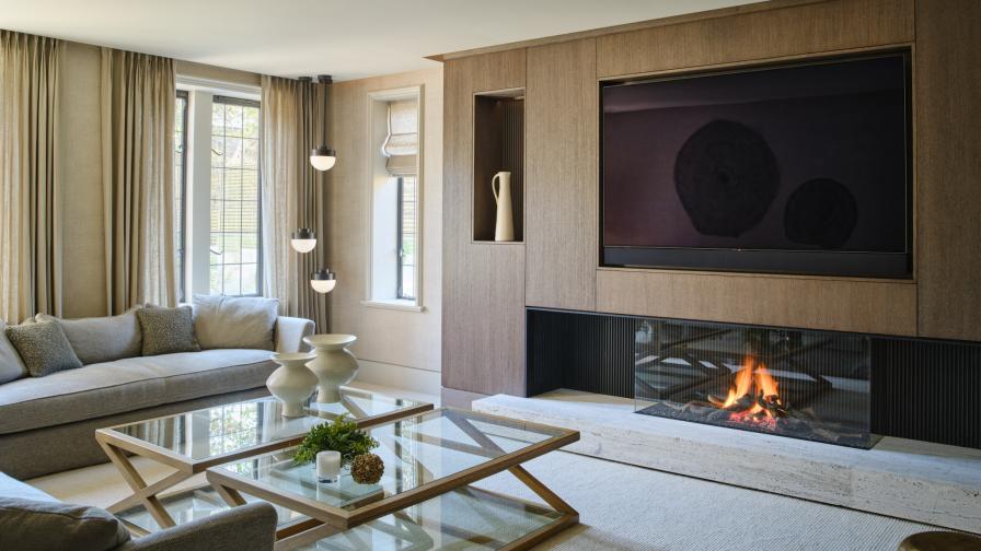 A wall of flat fronted cabinetry housing a large Tv in a snug