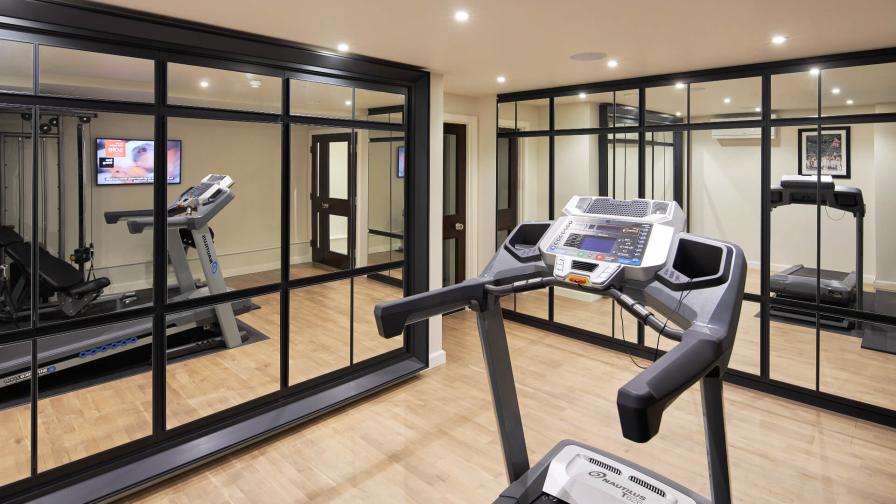 Mirror fronted cupboards in a home gym by Hetherington Newman