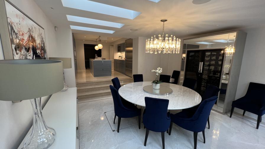 Dining table and kitchen, with Crestron Home control.