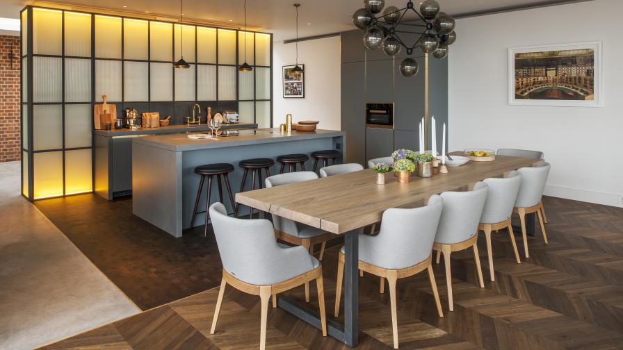 dining table with open plan kitchen and timber flooring