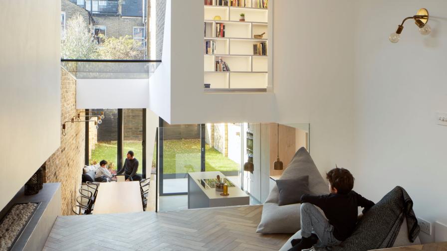 living room overlooking the open plan kitchen area with herringbone floor.