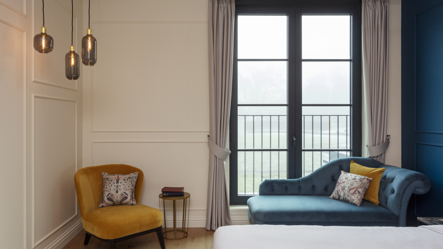 blue velvet chaise longue in hotel bedroom