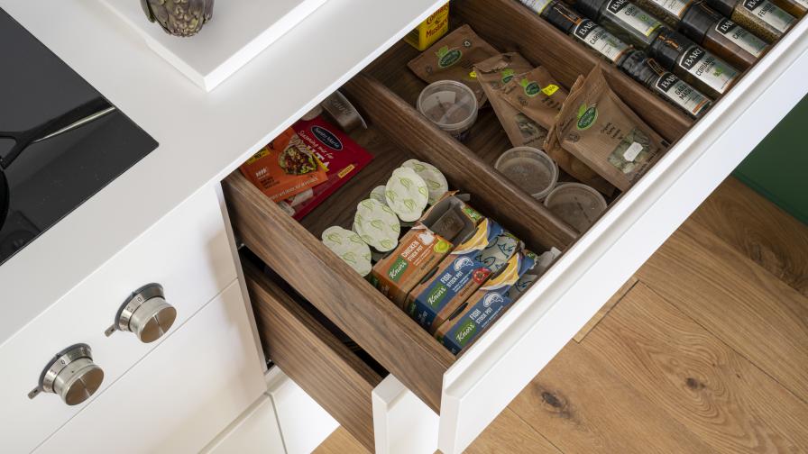 Walnut spice drawer with flush induction hob with a Corian worktop